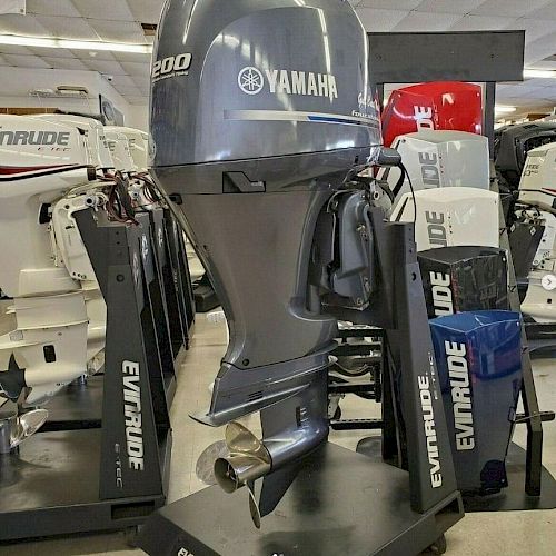 The image shows a Yamaha 300 outboard motor on display, surrounded by several Evinrude outboard motors, in what appears to be a showroom.